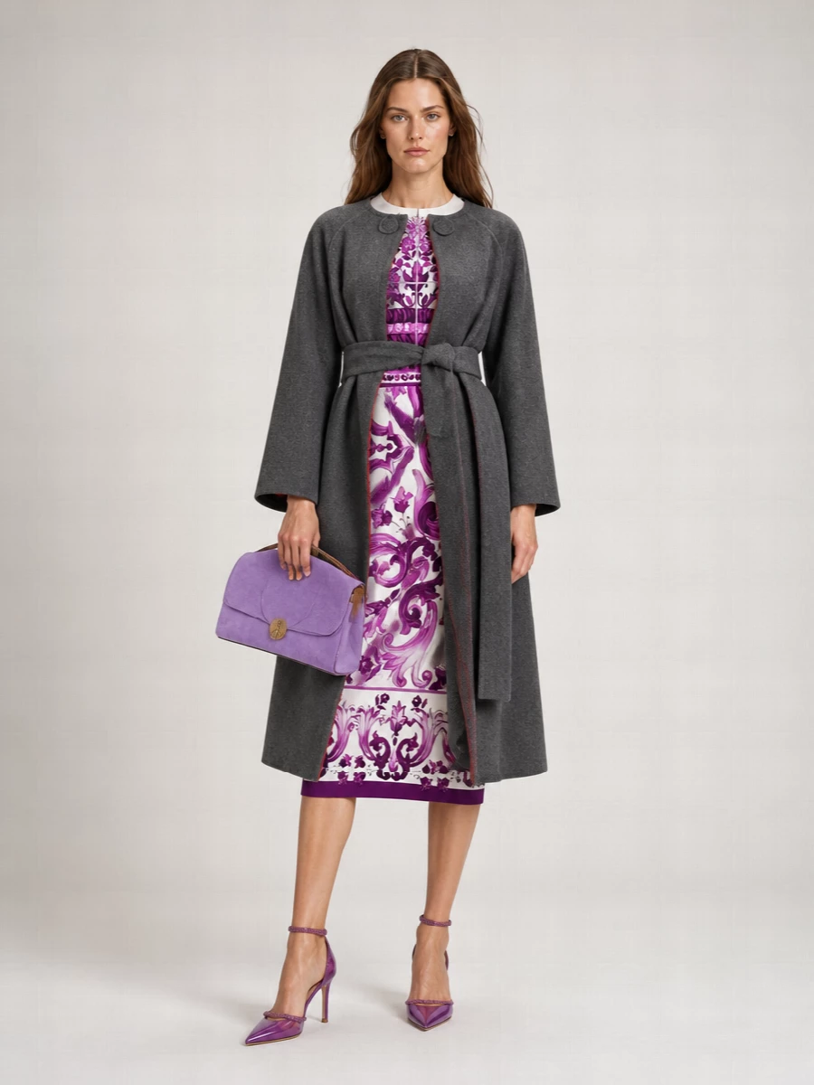 Orchid and plum scrollwork stay firmly center stage, grounded by sleek, crystal-trimmed purple stilettos that echo the dress without competing with its print. A plush lilac shoulder bag picks up the color story in a softer register, keeping the palette tight and the mood opulent but controlled for winter cocktail hours. The result is polished Italian drama with just enough restraint to read as modern quiet luxury rather than costume.