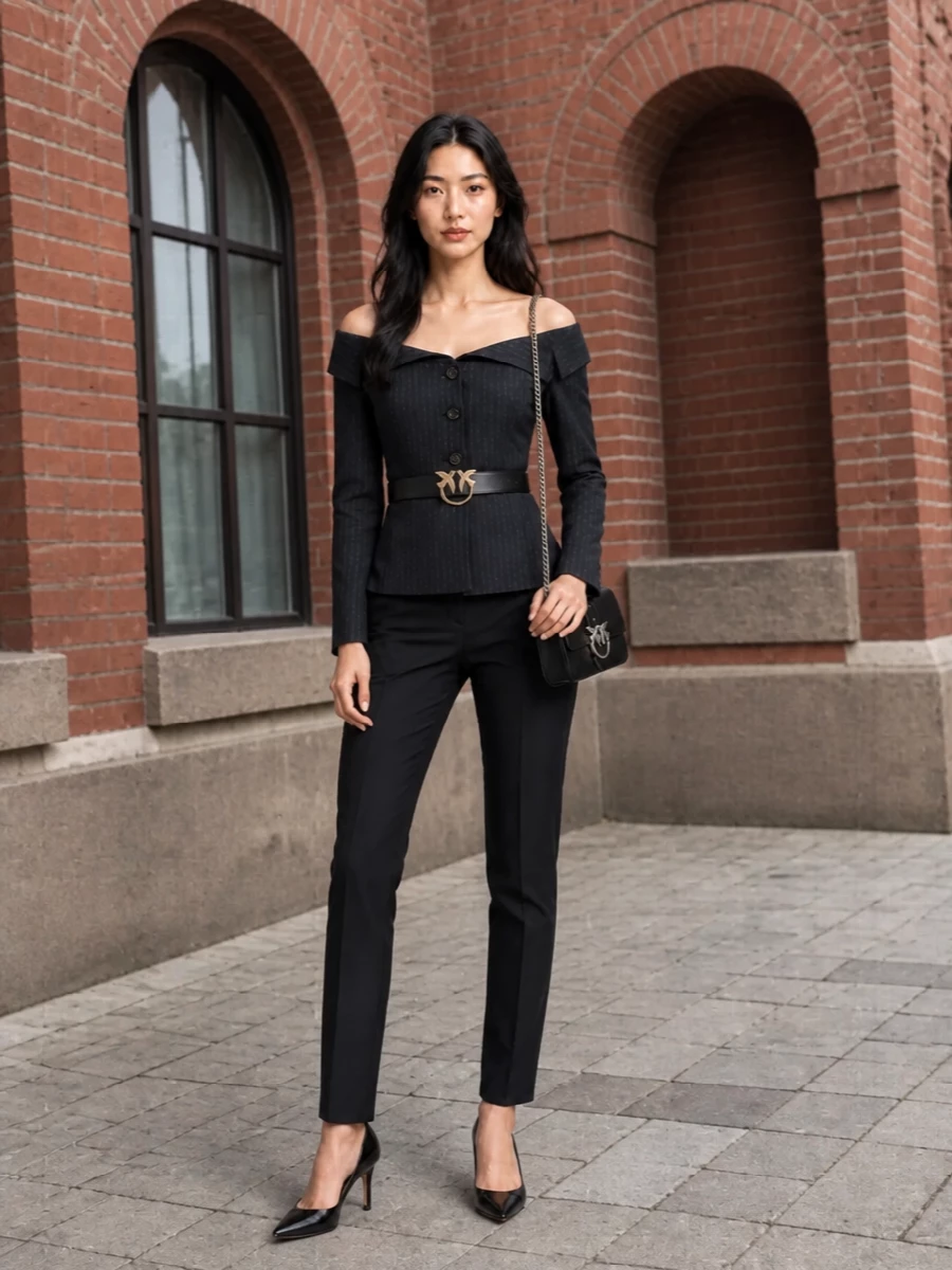 Quietly decisive, this pairing turns pinstriped tailoring into a modern evening statement. The ink navy trouser continues the long, lean line from the off the shoulder jacket, while black accessories keep everything sharp and restrained. It is made for boardroom drinks, gallery openings, and any night when suiting feels more interesting than a dress.