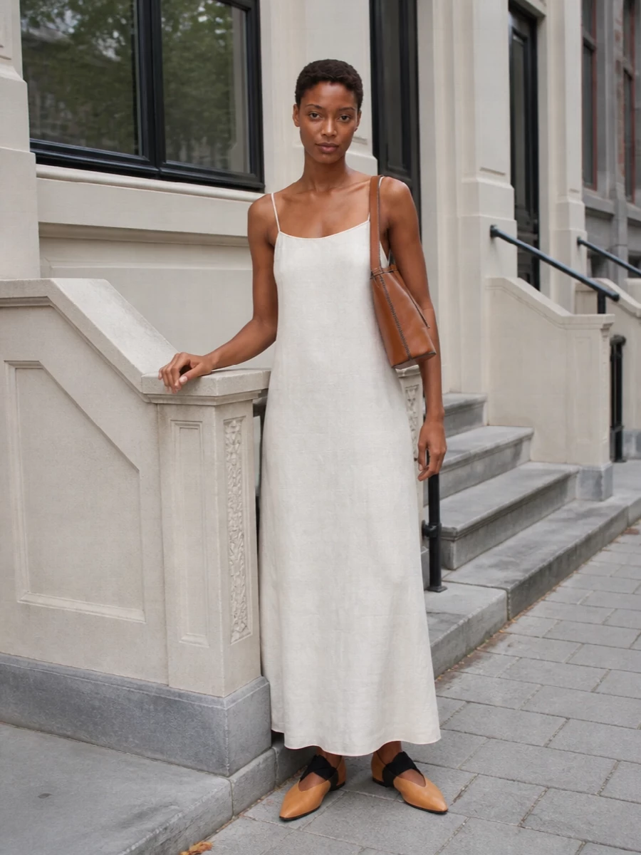 I chose the dress route to keep the mood minimal and fluid, letting the bag’s cognac tone sit against a soft off-white column rather than heavier tailoring. The Uma Wang slip dress and pointed flats create a clean, lengthening line in warm neutrals, with the bag adding quiet structure and depth through its black trim and gold hardware. Together they read as relaxed but considered city polish, perfect for warm days where you want ease with a precise finish.