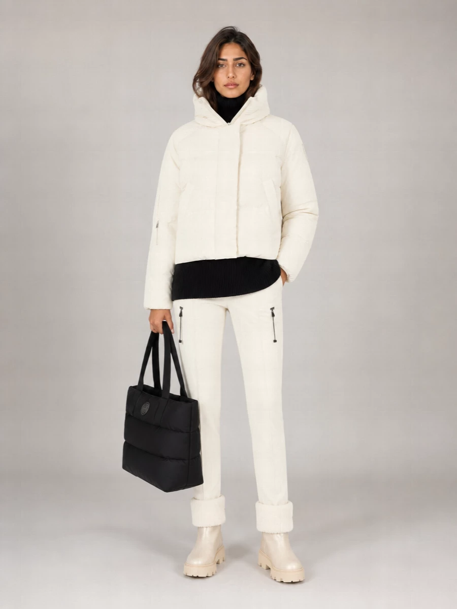 I’m building this around the jacket as a true outerwear anchor, so a knit-and-trouser route feels more modern and functional than layering a dress you’d never see under the crop. The result is a winter-white and black alpine city uniform: cocooned on top, slim and technical through the leg, grounded by tactile, shearling-cuffed boots and a padded tote that keeps the whole thing relaxed but quietly polished. It is the kind of cold-day outfit that moves from frosty city mornings to après plans without needing a change.