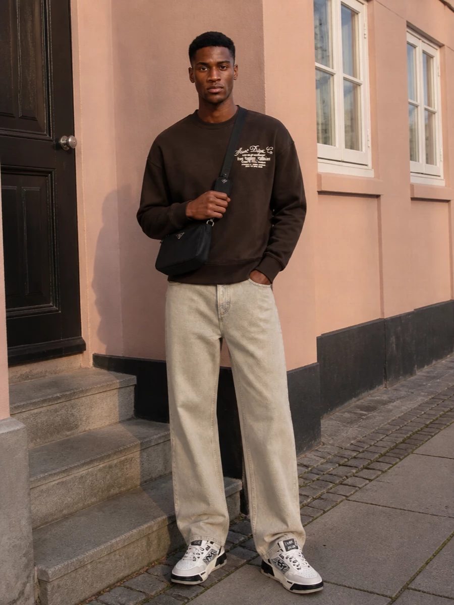 Amiri wide leg jeans brown sweatshirt prada bag