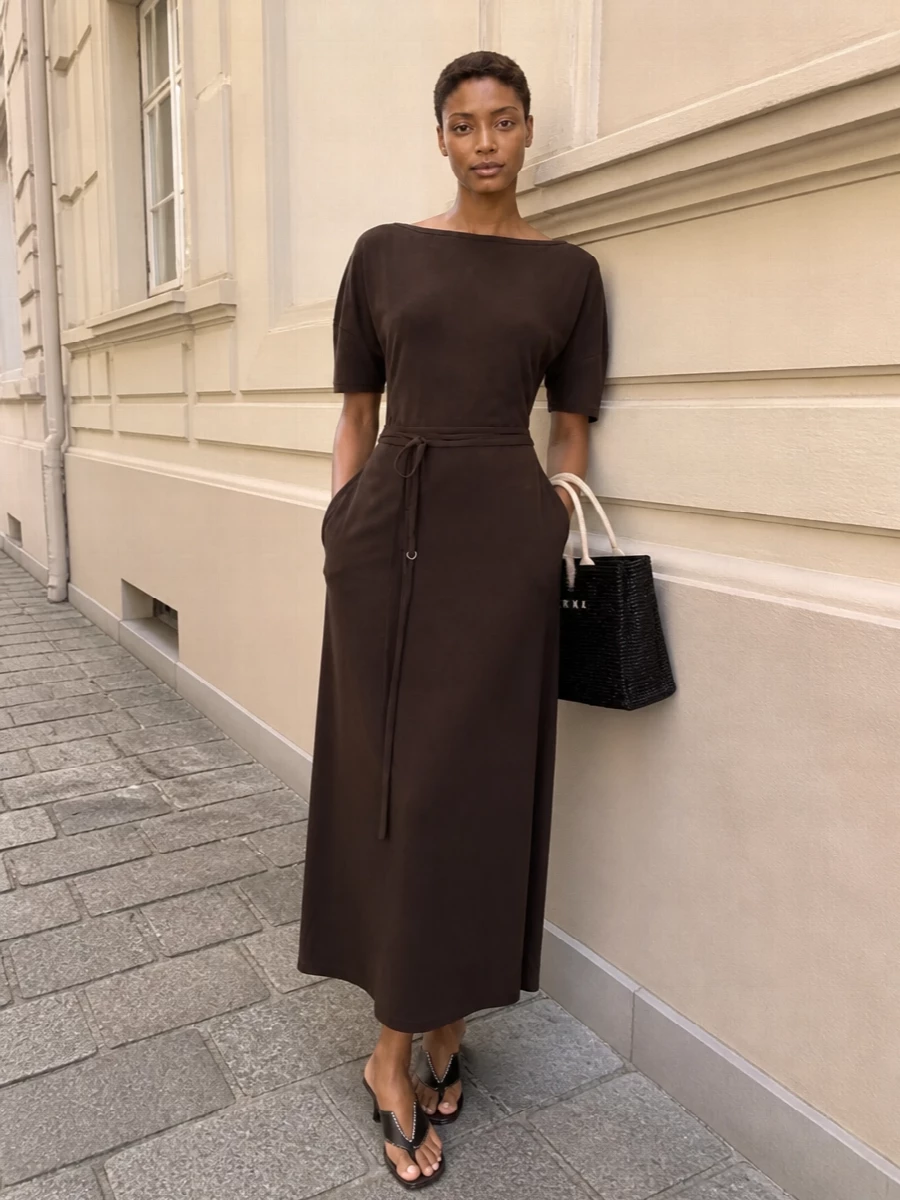 A dark chocolate Lemaire maxi with the black Marni woven tote creates a long, graphic line that feels calm yet intentional. The rich browns and blacks sit quietly together, with subtle texture doing the work. Espresso kitten-heel thongs keep it minimal and city ready, equally right for a terrace lunch or a low-key dinner.