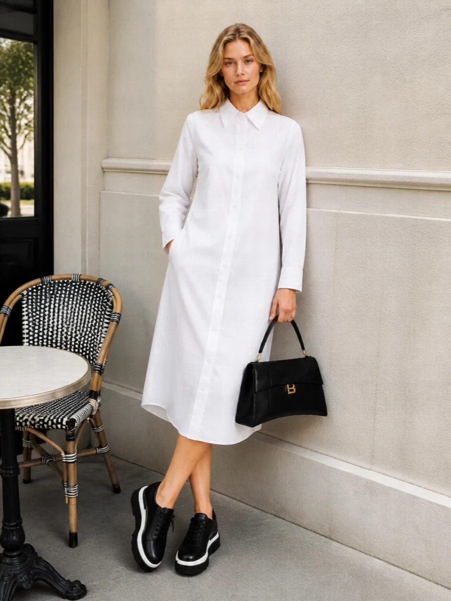 Opting for the shirt dress route keeps the palette tight and lets the sneakers’ height play against a long, clean line rather than breaking it with separate top and trouser volumes. The Balenciaga white midi shirt dress and sculptural black top‑handle bag create a precise black and white story that feels modern, discreet and gallery‑dinner ready with the platform sneakers adding attitude without noise. It is a quietly assertive city ensemble that reads luxurious through cut and proportion, not branding or color.