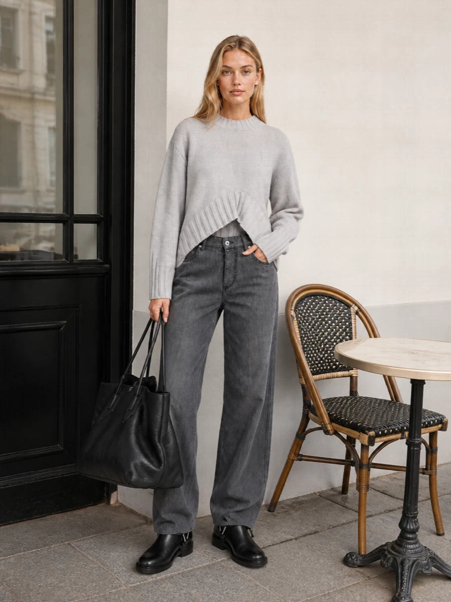A soft grey Attico knit and Bottega’s charcoal wide-leg denim sit perfectly with the oversized black tote, keeping everything relaxed but sharply minimal. The clean black ankle boots echo the bag’s quiet structure, so the volume reads intentional rather than casual. Choosing top and trouser over a dress keeps this firmly in polished day-to-night city territory rather than overt eveningwear, which suits the tote’s nonchalant scale.