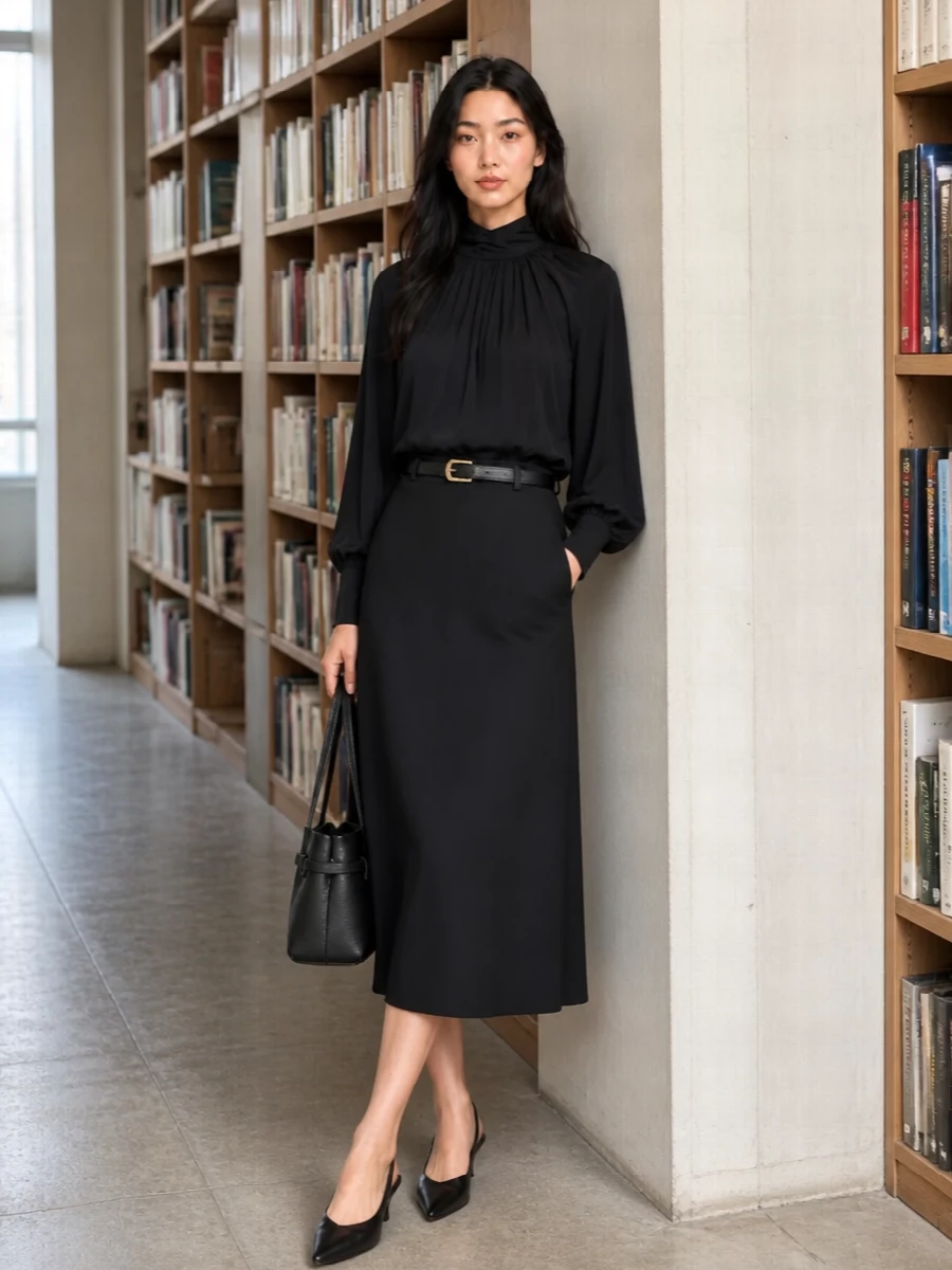 A monochrome study in line and movement, this pairing lets the gathered mock neck and sweeping black midi do the talking. The pointed slingback and structured shoulder bag sharpen the silhouette just enough, while a slim belt is there if you want a touch more definition without losing the softness. It is tailored, polished and quietly confident for anything from client dinners to gallery nights.