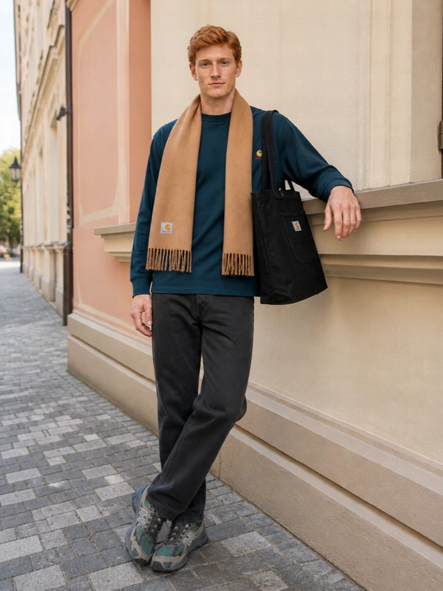 Teal, charcoal and camel stack into a grounded Carhartt uniform that feels ready for long city days. The straight-leg work pants and chunky New Balance runners keep the silhouette relaxed but not sloppy, while the black tote and camel scarf add just enough structure and warmth to feel considered. It is an easy streetwear setup that leans hard into utility detailing and muted color rather than loud graphics.