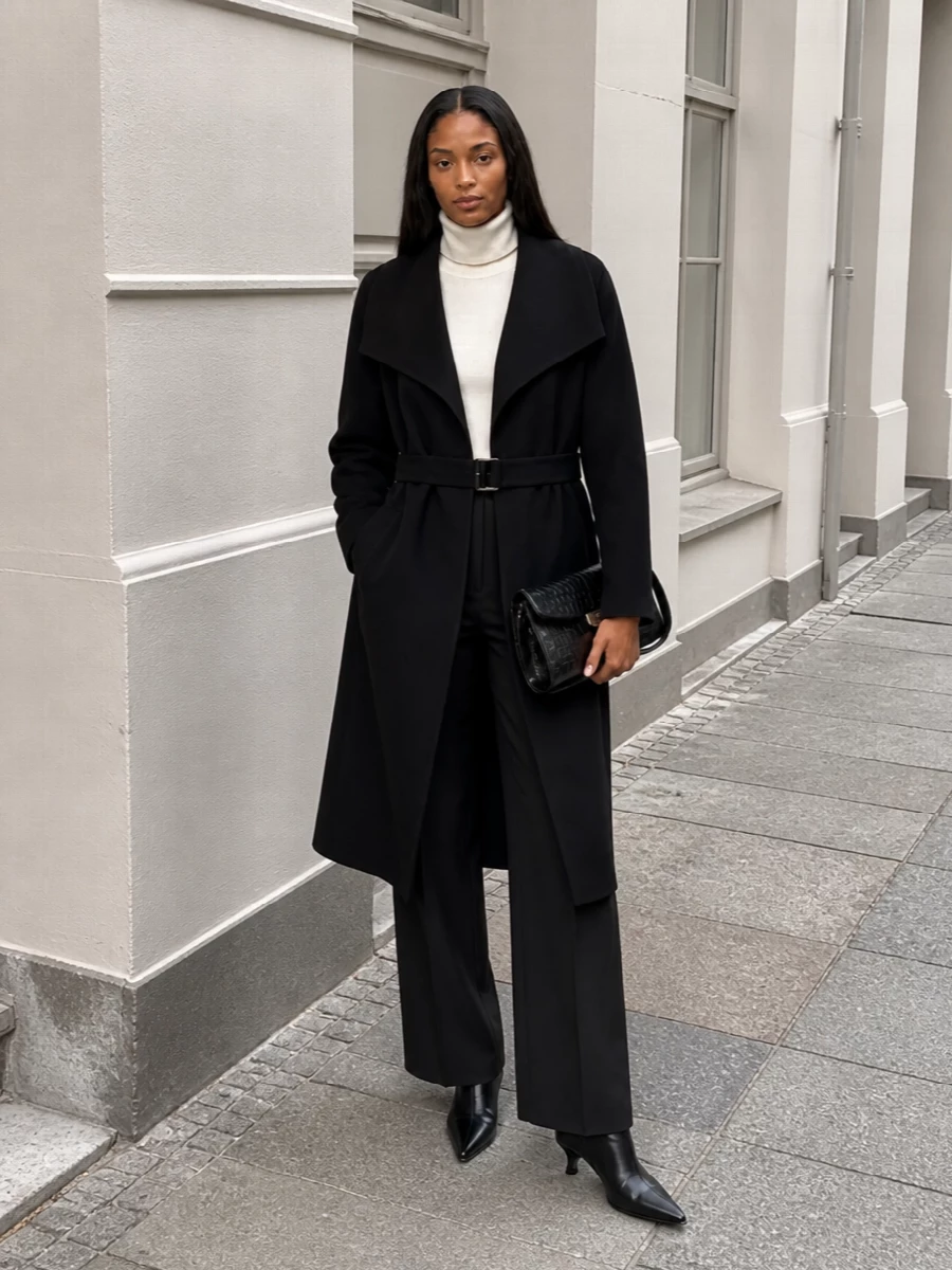 I am building around the coat as tailoring, so a top and trouser path feels truer to its gallery-to-dinner potential than layering over a dress. The ivory turtleneck and black high-rise wide leg create a clean vertical column under the coat, with the pointed ankle boots and croc clutch sharpening the silhouette into something city-evening ready but still understated. It is all Totême lines and textures, just enough contrast to feel intentional, and no detail that competes with the coat’s belt and lapels.