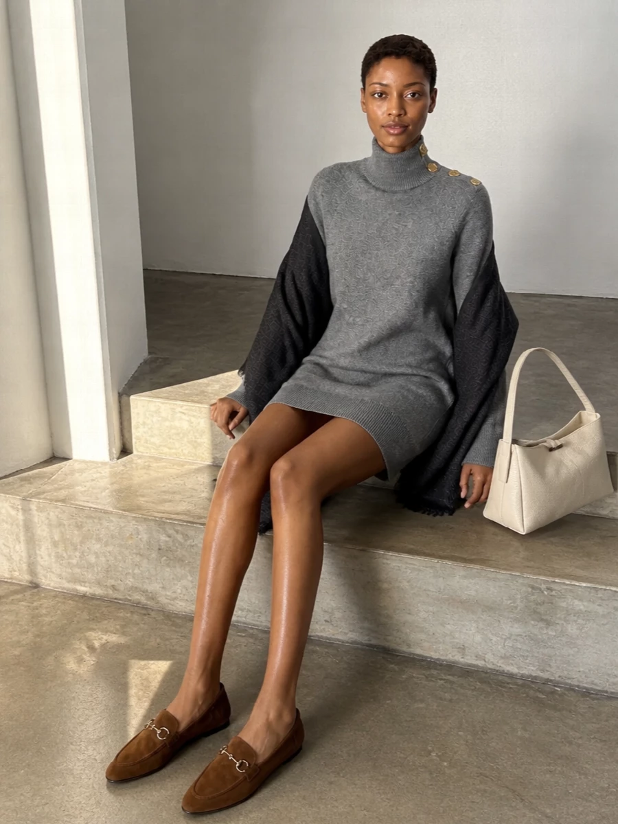 I chose the dress path, building around a single grey knit column so the Tory Burch wrap reads as a considered layer, not another separate competing with a top and bottom. The Balmain dress and monogram scarf sit in the same quietly luxurious, logo-subtle space, while Gucci’s pointed brown loafers and a clean ivory tote add warmth and structure without breaking the calm palette. The result is a city-ready winter outfit that feels cocooning, elongated and discreetly branded from head to toe.