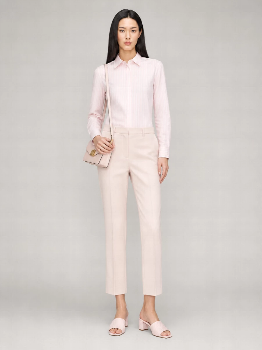 Soft blush tailoring on blush creates a calm, monochrome column that feels composed without ever reading stiff. The cropped trouser and square-toe mule subtly lengthen the leg, while the small structured bag keeps the finish precise and modern. It is an easy desk-to-dinner pairing for warm days when you want polish in a very quiet key.