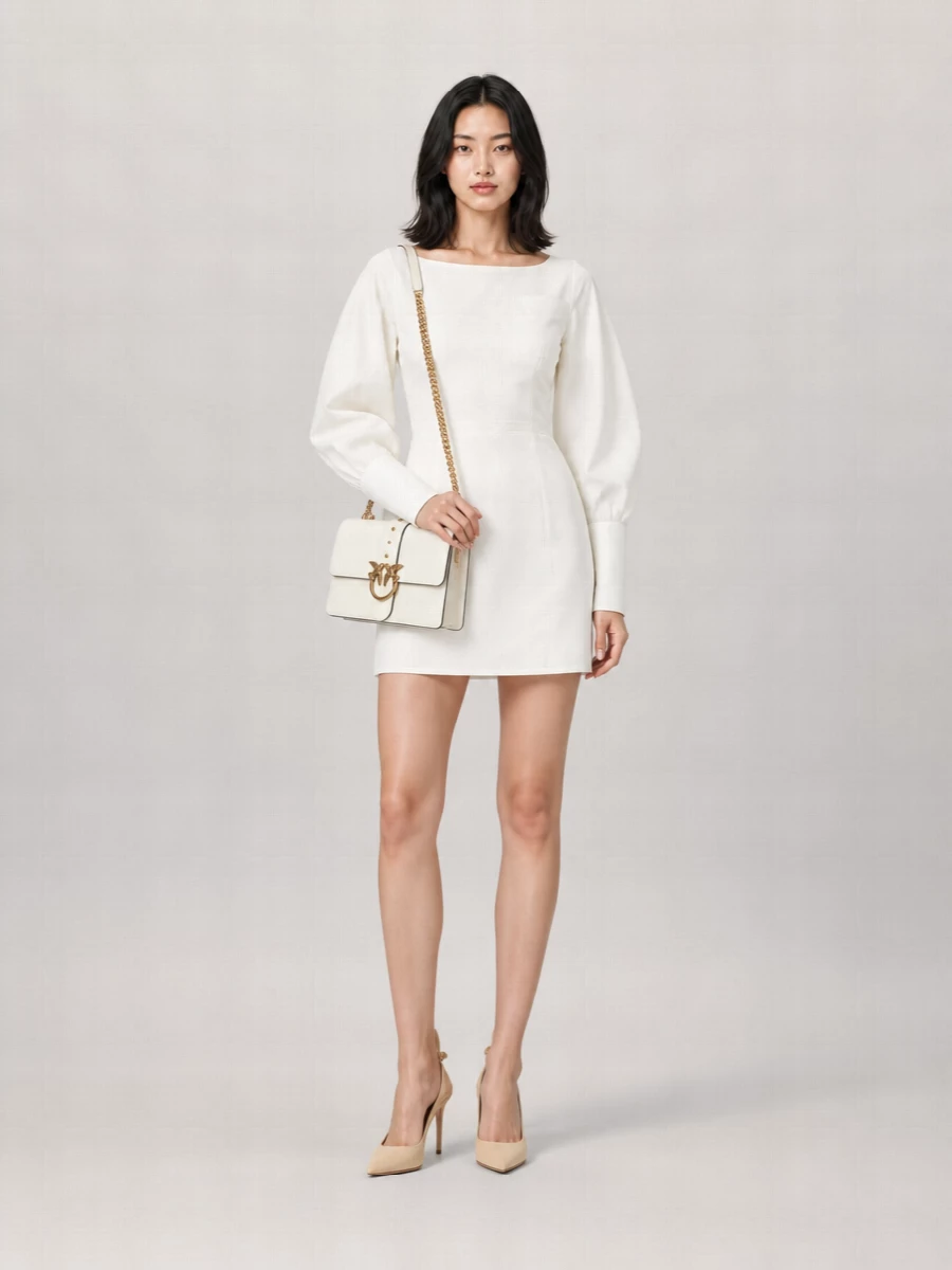 A sharp white mini dress and nude suede slingbacks frame the ivory Love Bag in a palette of clean neutrals that feels modern and romantic rather than sweet. The structured lines and subtle cut-out detailing keep the outfit cocktail-ready while still reading quietly luxurious. Choosing the dress route rather than separates lets the bag stay the hero piece, with just enough softness from the nude suede to keep it feminine and polished for autumn and winter evenings.
