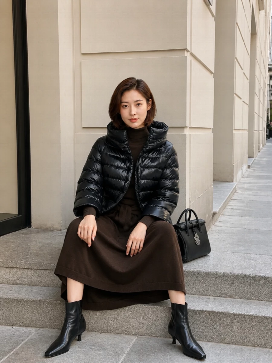 I am building around the dress option rather than top and bottom, as the knit midi gives a continuous, elongated column that pairs best with the cropped puffer’s sculpted volume. The dark chocolate Lemaire dress, inky Totême ankle boots and structured black Zanellato bag create a quietly luxurious, sport-leaning winter ensemble that feels composed but easy. It is the kind of outfit that moves from desk to late dinner without needing a change, with the puffer adding modern, technical contrast to the soft knit base.