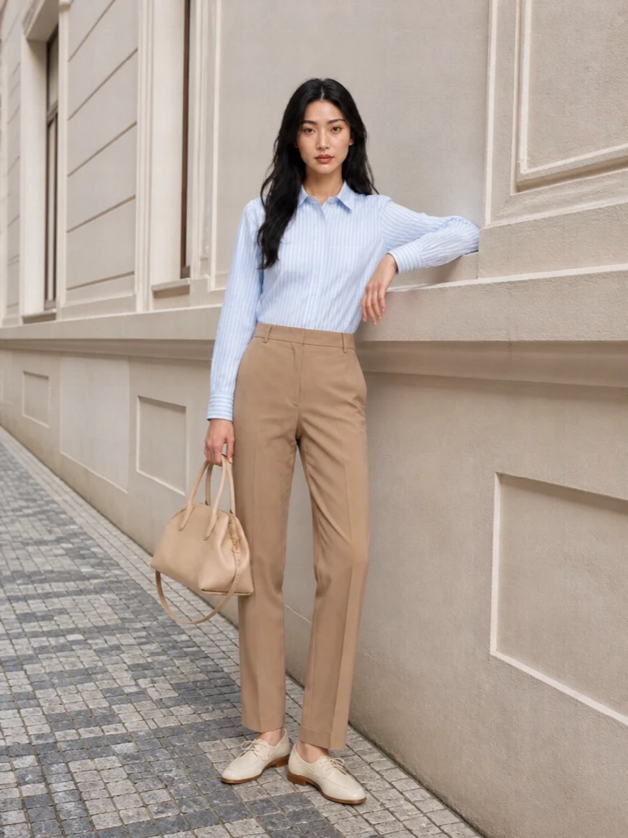 The striped Max Mara shirt is grounded with softly relaxed camel tailoring for a quiet, Italian take on workday polish. Cream loafers and a nude structured tote keep the palette light and tonal, so the whole outfit feels composed without tipping into stiffness. It is boardroom appropriate yet still easy enough for a long city afternoon.