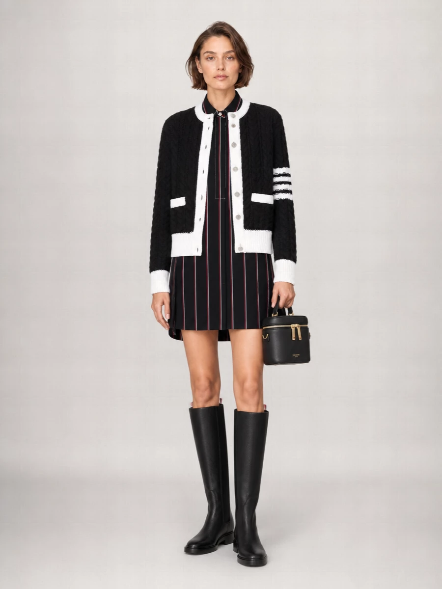 I’m anchoring this around the shirting mini rather than a separate top and bottom so the cropped cable jacket can sit cleanly over one uninterrupted column of stripes. The result is very Thom Browne uniform, all in a tight black, white, and ink palette with elongated boots to balance the short hem. It reads like a disciplined winter city uniform, quietly graphic but still soft with all the knit texture.