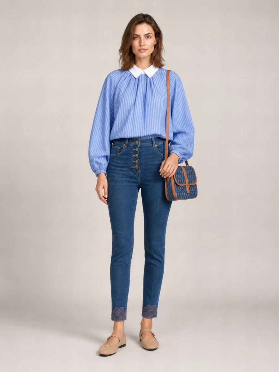 Romantic denim gets a preppy twist with the striped Patou blouse tucked into Valentino’s lace-trimmed slim jean. Taupe Prada Mary Janes keep the line soft and polished, while Saint Laurent’s monogram denim shoulder bag ties the indigo tones together with a subtle collegiate nod. The result is refined day dressing that feels considered yet quietly playful for cooler seasons.
