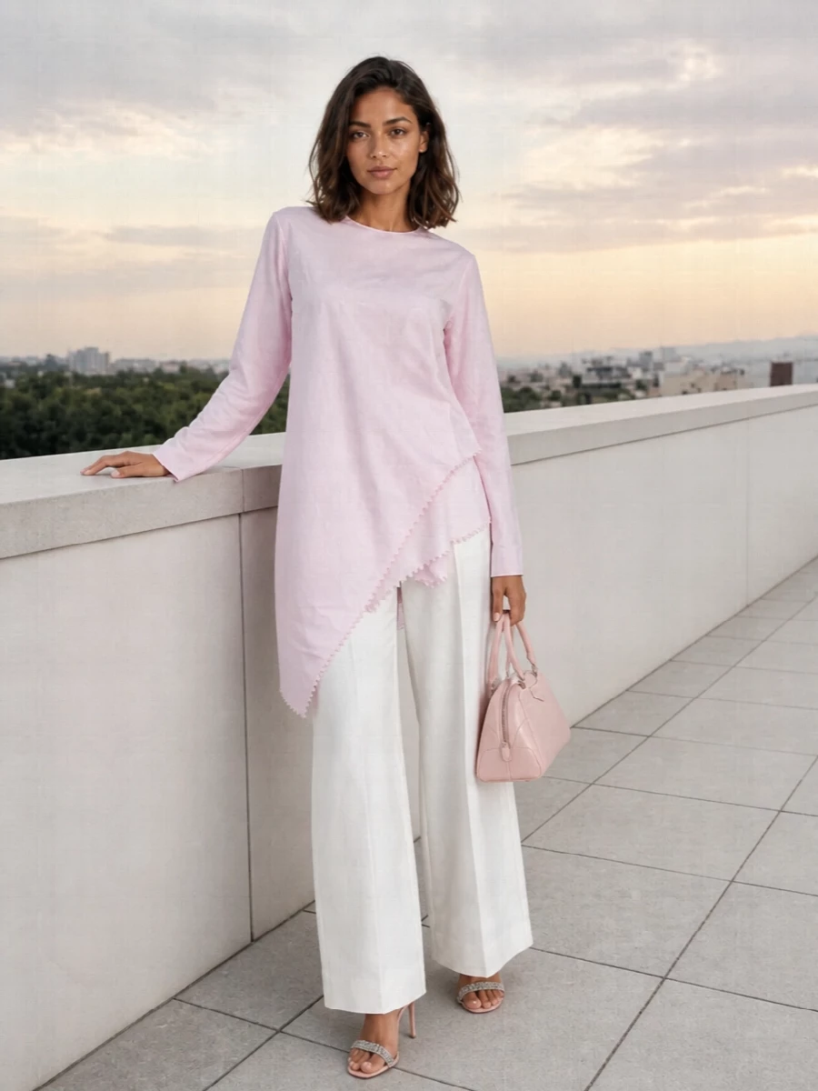 This look leans into sculptural romance with the blush Jacquemus tunic floating over clean, high-waisted soft-white wide-leg trousers for a long, modern column. Blush Manolo stilettos and the structured Givenchy top-handle keep the palette whisper-soft while adding just enough polish and sparkle to take the outfit from gallery afternoon straight into an elegant dinner. The result is airy, architectural and unmistakably quiet luxury.