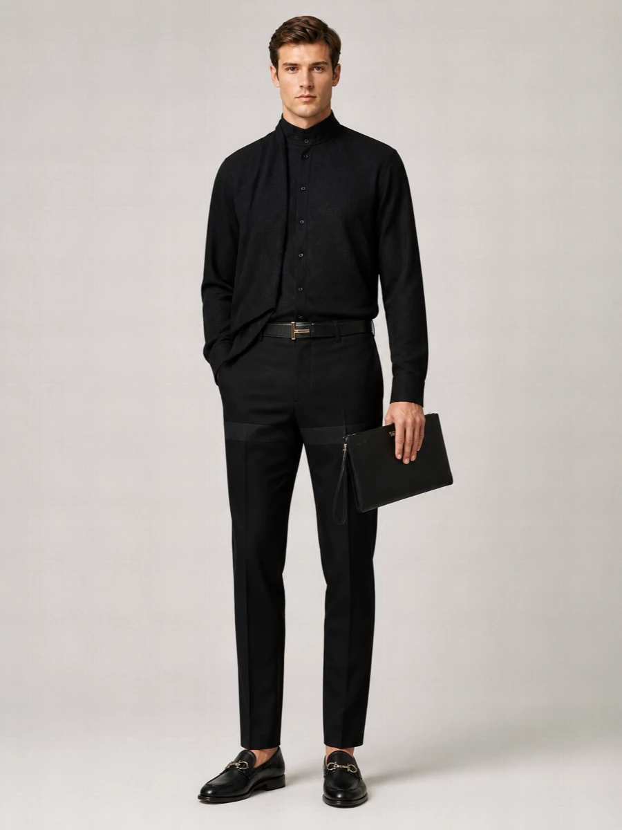 This is a modern evening uniform built around precision: a Tom Ford belt, a fluid Ferragamo shirt and slim tux-influenced trousers, anchored with impeccably clean black loafers. The palette stays purely monochrome so the interest comes from cut, drape and subtle sheen, finished with a structured Valentino clutch for a composed, gallery-or-restaurant-ready finish.