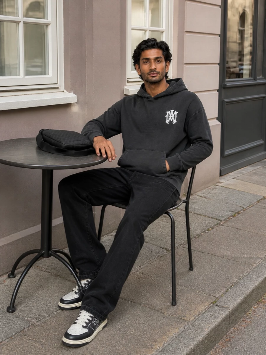 Washed-black Amiri on top and bottom builds a tight, grunge-leaning street vibe that feels considered rather than over-styled. The straight denim balances the regular hoodie with a clean line, while the skate-inspired sneakers and Gucci sling keep everything grounded in premium, logo-hit streetwear without shouting. It is an easy city uniform for days that run from studio to late-night runs.