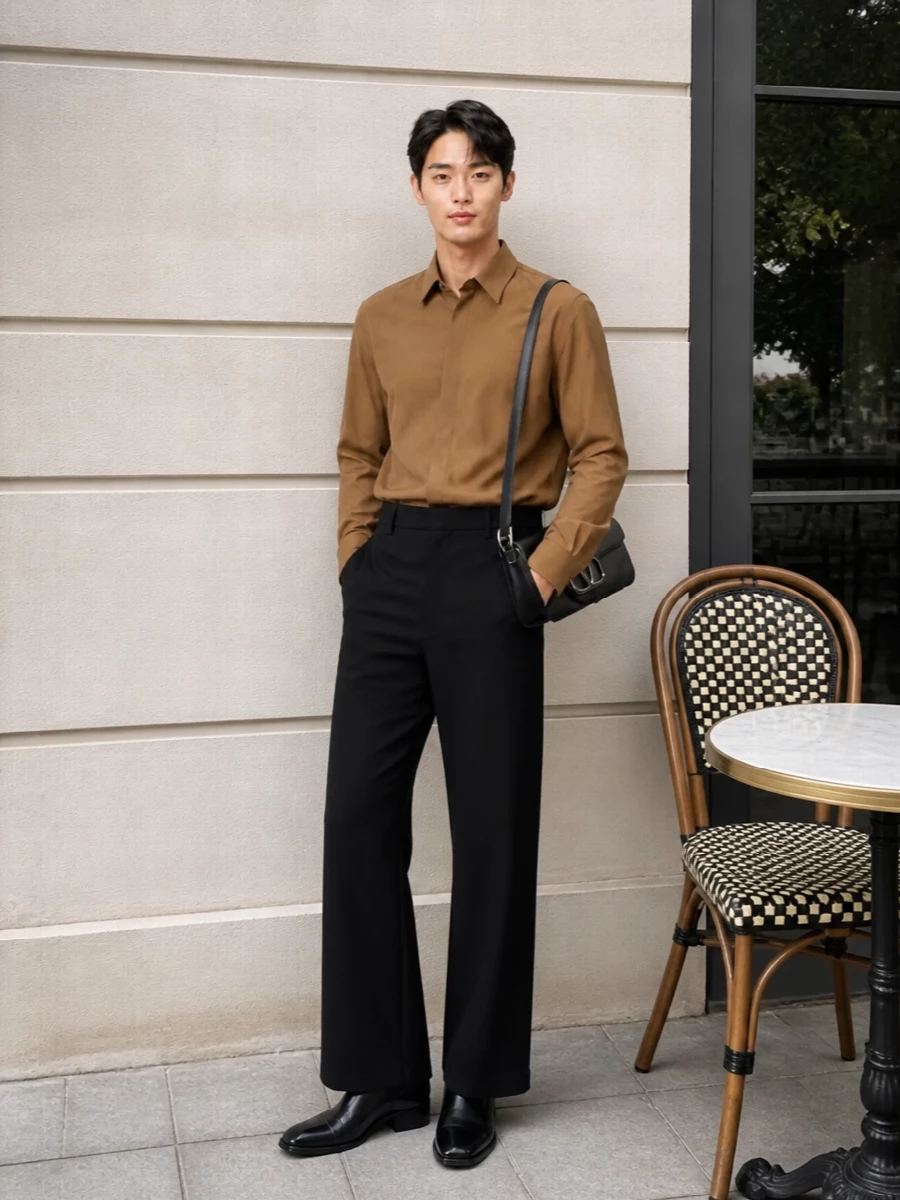 Black wide-leg tailoring with a clean camel shirt creates a calm, graphic contrast that feels precise without being stiff. Glossy black Chelsea boots keep the line modern and streamlined, while the slim black shoulder bag reinforces the minimalist, quiet-luxury attitude.