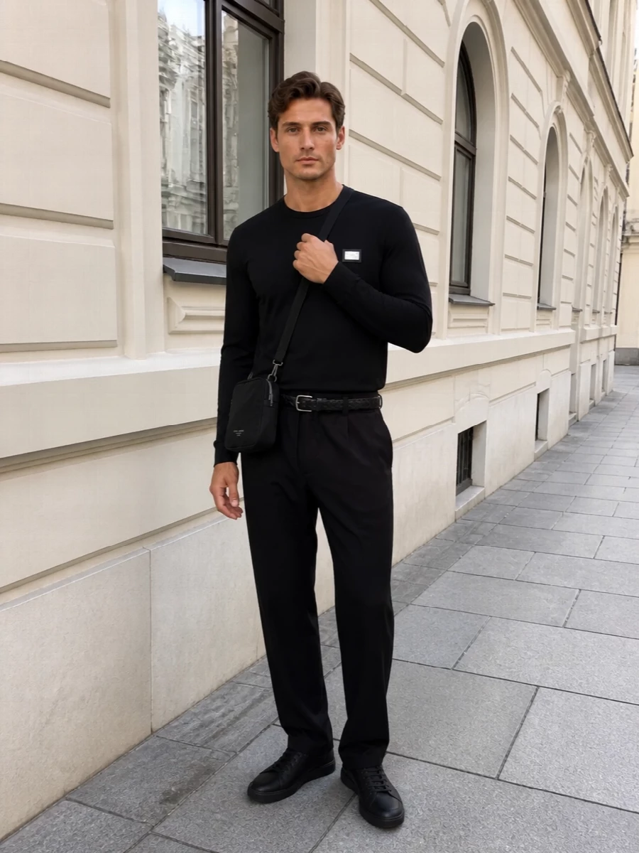 An all-black, quietly branded lineup keeps the focus on line and texture rather than noise. The relaxed drawstring trouser and streamlined sneakers sit in the sweet spot between streetwear ease and discreet Italian polish, while the compact crossbody and subtle belt add just enough structure to feel considered without breaking the minimalism.