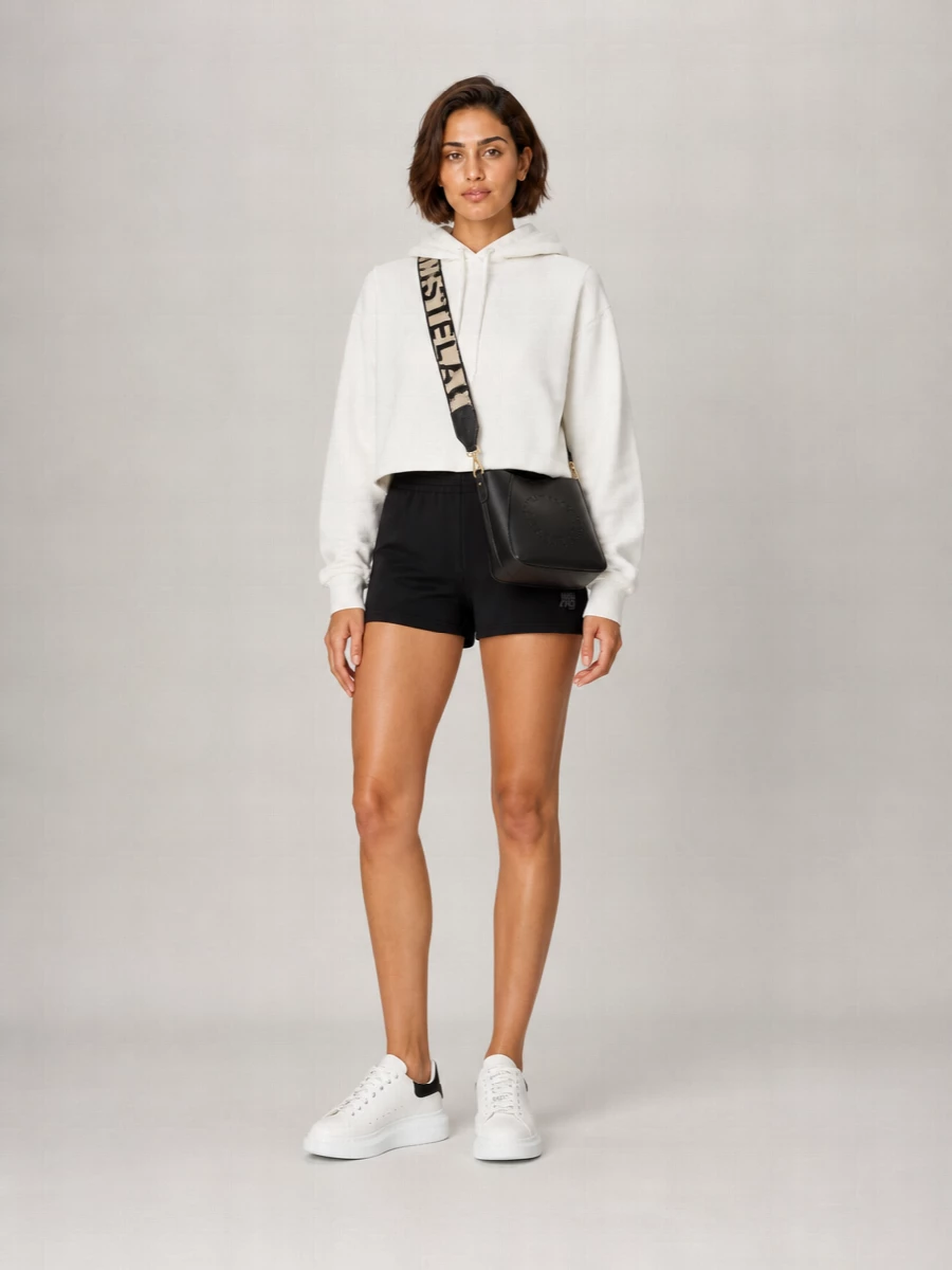 Soft white on top and black on the bottom create a sharp, minimal contrast that still feels relaxed and easy. Chunky white sneakers keep the energy sporty while the structured black crossbody adds just enough definition. It is an off-duty city uniform that reads clean, graphic and pulled together without trying too hard.