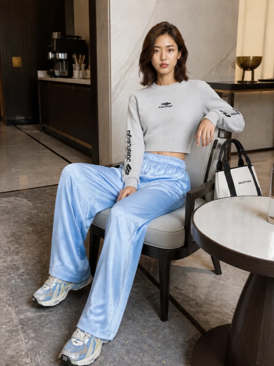 This reads as a laid-back Balenciaga street set built around the runner’s icy palette, with the cropped grey knit and ice-blue satin trouser echoing its greys and blues without feeling literal. The wide, fluid leg against a compact top keeps the silhouette modern and relaxed while still sharp enough for the city. I chose the top and trouser route over a dress so the sneaker’s sport character could sit in its natural context: athleisure-meets-lounge rather than night-out.