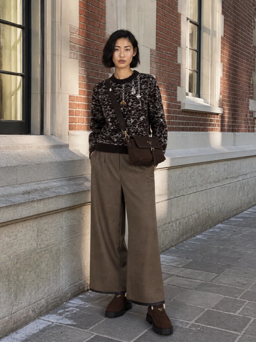 This outfit leans into a cocooned, streetwise take on quiet luxury, anchoring the chunky shearling loafers with a textured espresso knit and fluid taupe wide-leg trousers. The high waist and long leg streamline the volume at the ankle, while the chocolate cross-body adds a subtle technical note that keeps everything feeling modern and city-ready. I chose the knit-and-trouser route over a dress to let the shoes read as the focal point and to preserve an easy off-duty attitude rather than pushing the look into occasionwear.