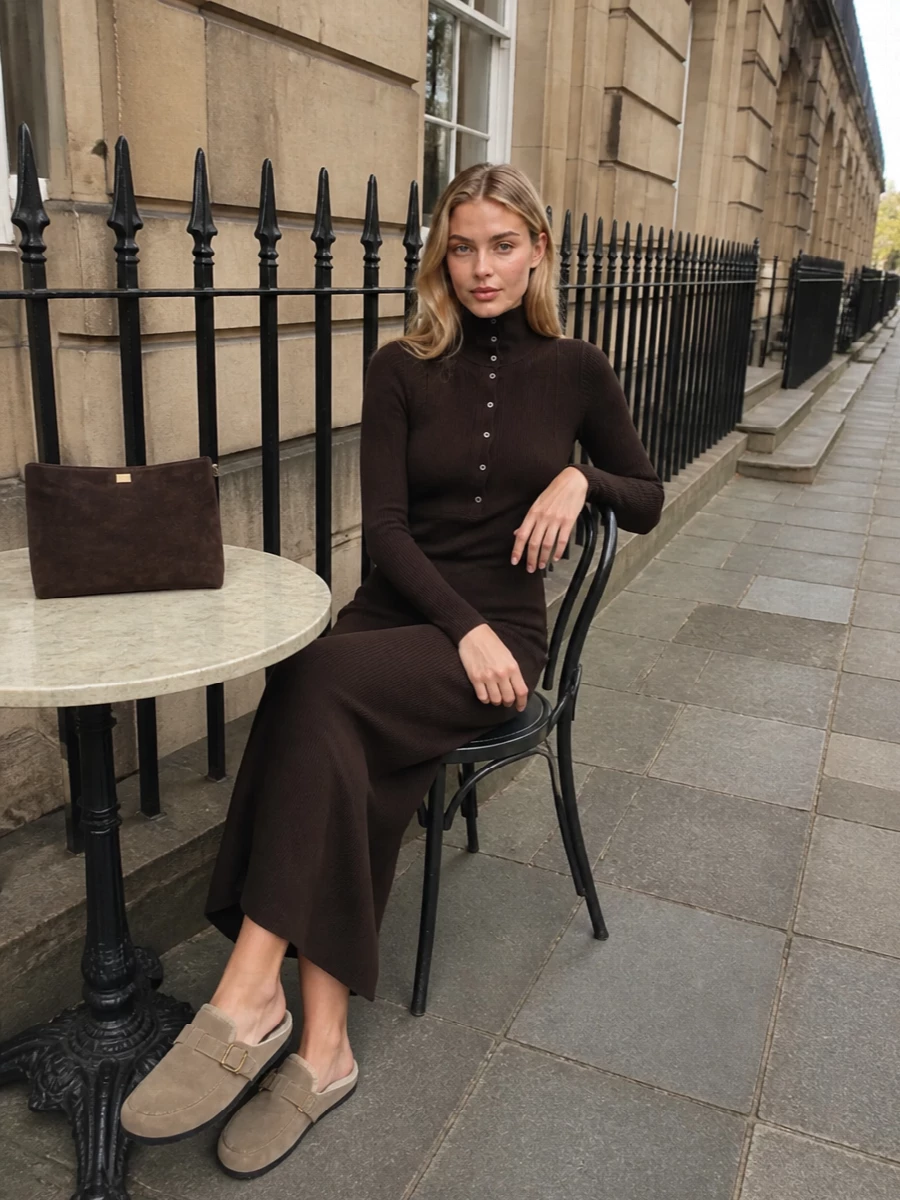 I am anchoring this with the Tom Ford ribbed chocolate sweater dress rather than separates, because its long column and high neck echo the slipper’s cocooned mood while feeling more intentional and composed. The deep brown dress grounds the softer taupe of the Prada loafer, and the suede chocolate shoulder bag keeps the palette rich and tonal without competing logos. Together, it reads as a quietly preppy winter knit story you can wear from at-home hosting to understated city evenings with a simple swap of jewelry or outer layer.