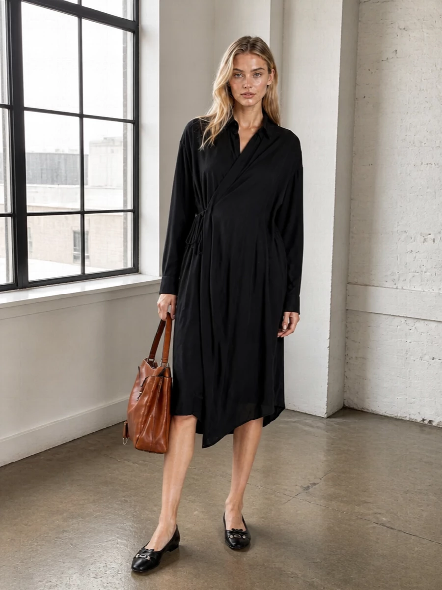 This pairing centres on the black asymmetric shirt dress, letting the cognac top-handle bring quiet warmth against a clean, monochrome base. The sharp yet relaxed cut keeps it suitable for work days that slide into early dinners, while the sleek ballerina flats ground everything with an unfussy, modern finish. I chose the dress route over separates to echo the bag’s structured simplicity and avoid fragmenting the silhouette with extra lines.