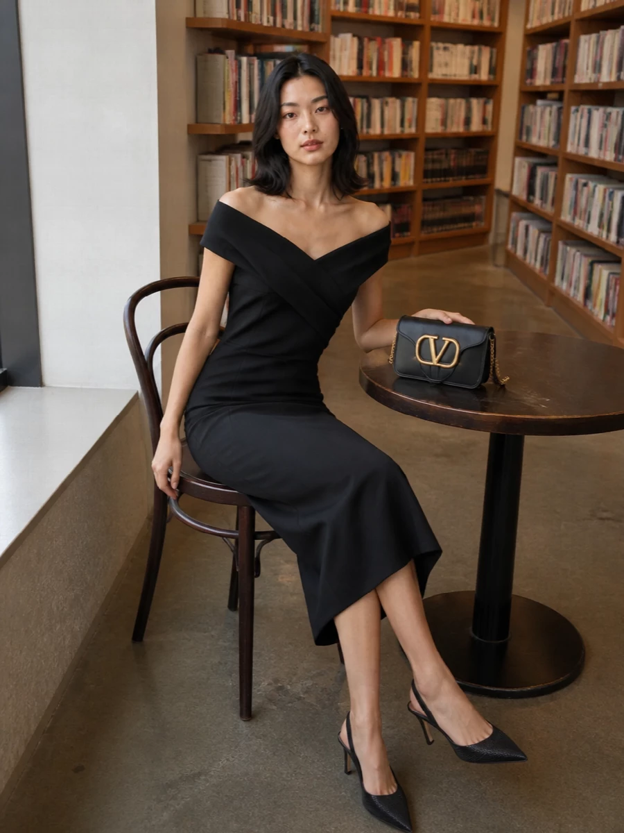 A sculpted off-shoulder black midi and crystal-dusted slingbacks frame the Valentino clutch as the single bold hardware moment. The clean column, bare shoulders and subtle shimmer keep the mood romantic yet disciplined, ideal for formal dinners or black-tie invitations. Choosing the dress route over separates lets the bag and jewelry speak softly without competing textures or hemlines.