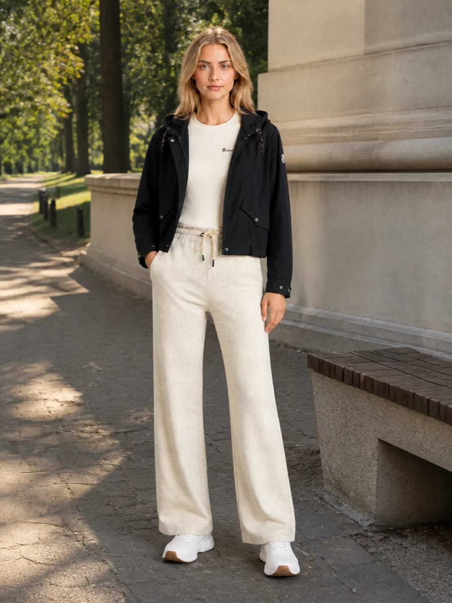 I am building around the top and bottom path rather than a dress, so the Moncler bomber can read as true technical outerwear over a sport-luxe base instead of fighting a one-piece silhouette. The ivory logo tee, soft flared lounge pant and white runners create a monochrome, athletic column that feels relaxed yet considered, with the black cross-body quietly tying back to the jacket. It is a modern travel-to-city combination that leans into performance cues while staying firmly in a luxury register.