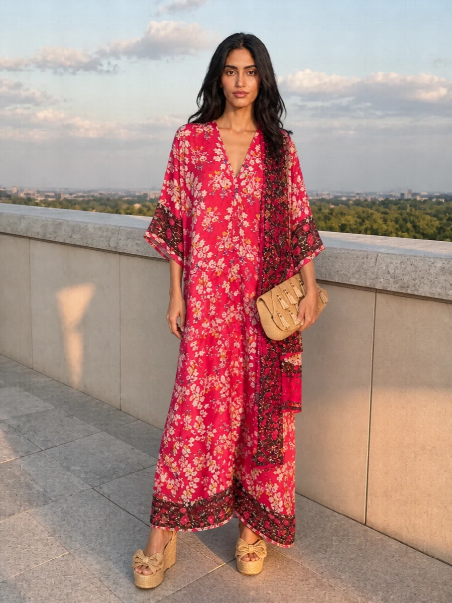 A fuchsia floral kimono maxi takes center stage, balanced by natural raffia wedges that lift the hem and keep the mood relaxed yet refined. A straw-toned sculpted clutch and coordinating floral scarf pull in the dress’s warm, boho notes for sun-drenched dinners and late garden parties.