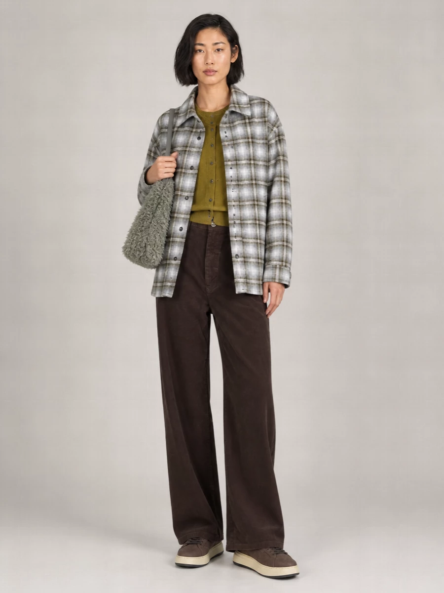 I’m skipping the dresses and building around the outerwear’s relaxed, off-duty mood, so a soft knit and easy wide-leg trouser feel more authentic than a single-piece anchor. The grey‑olive plaid shacket, olive cardigan and dark brown corduroy read like a considered campus-uniform in neutrals, grounded by streamlined taupe sneakers. A mossy faux‑shearling shoulder bag picks up the grey tones and adds just enough texture for a quietly graphic, winter-in-the-city outfit.