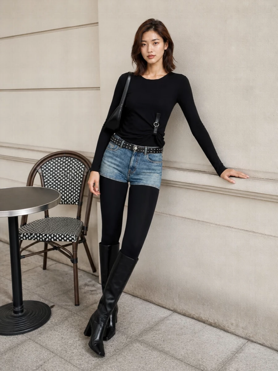 A sharp black Coperni top twists clean lines around the body, setting up the hybrid stirrup legging-denim short as the focal point. Sculpted knee boots run seamlessly into the stirrups for a long, graphic leg line, while a curved glossy shoulder bag and a slim studded belt inject just enough hardware to underline the night-out energy without breaking the minimalist palette. It is pure Paris-after-dark sport meets Y2K, all in a tight, body-conscious silhouette.