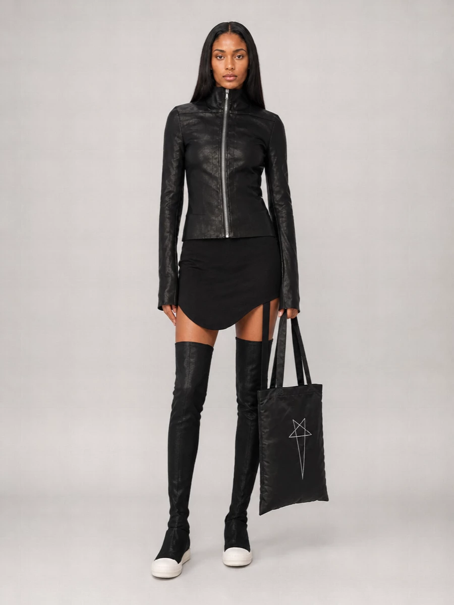 I’m taking the dress path here, because the bodycon slip plus over-the-knee sock boots create a clean, elongated base that lets the sculpted leather jacket stay the hero without extra seam noise from a separate top and bottom. The result is a tight Rick-centric column in deep black, with the tote and sneaker-sole boots pulling it toward a night-city, streetwear register rather than classic cocktail. It reads like a severe, modern uniform you can wear from a late gallery opening straight into a basement club.