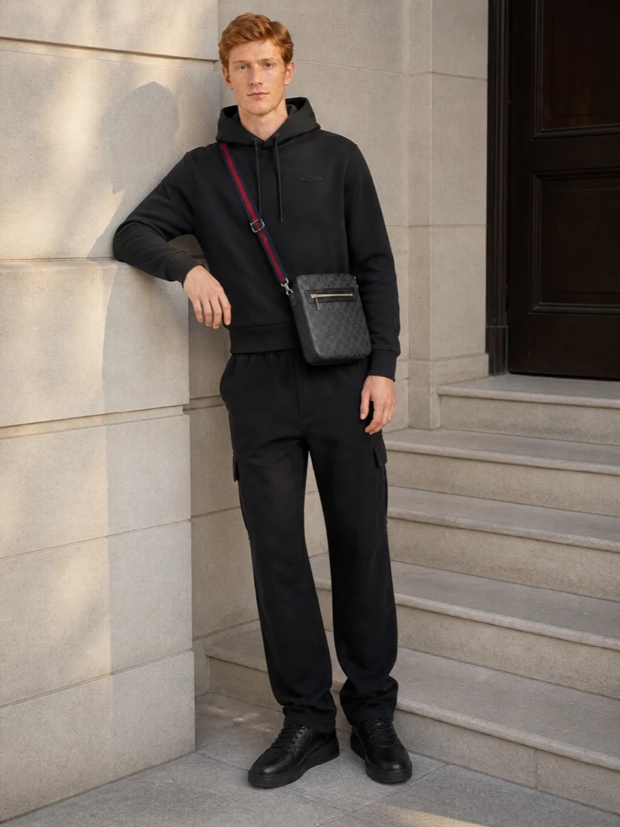 This is a quietly assertive city uniform built around deep charcoal and black, letting the Gucci crossbody’s strap add the only hit of colour. The structured hoodie and relaxed cargos keep it easy and functional, while the sculpted black sneakers sharpen the silhouette for all-day movement. It feels considered without trying, ideal for commuting, travel or long off-duty days in the city.