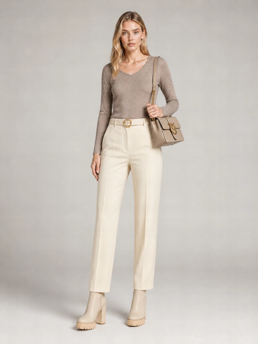 Taupe and buttercream sit together in a soft, tonal palette that feels calm and polished, with the knit’s subtle shimmer playing gently against the clean tailoring of the trouser. Cream ankle boots and a taupe flap bag keep the line long and cohesive, while the slim ivory belt quietly defines the waist for a neat, modern profile. It is an easy neutral uniform that moves from relaxed office days to quiet dinners without ever feeling overdone.