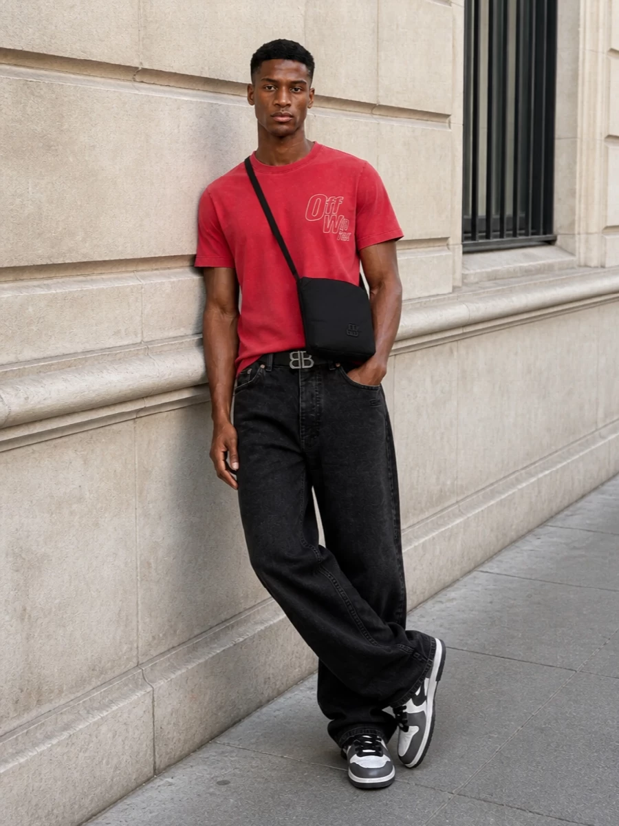 The washed red Off-White tee sits against washed-black wide-leg denim for a modern, monochrome-heavy street silhouette with the color pop kept high on the body. Graphic Off-White court sneakers in white, charcoal, and black echo the tee’s sporty attitude, while the padded black Balenciaga crossbody and slim BB belt add refined, urban utility without stealing focus. The result is an elevated off-duty uniform that feels directional yet totally effortless for FW city wear.