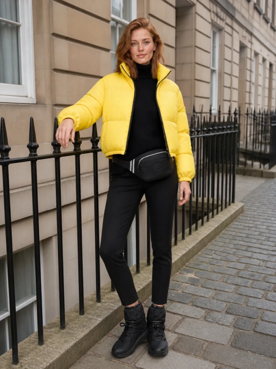 I’m building this around the puffer as a sharp winter shell with a clean, technical base rather than competing knitwear or dresses. The oversized black turtleneck and slim Moncler Grenoble pants create a long, dark column that lets the cropped yellow jacket hit as a graphic block of colour, while the snow sneaker-boots and belt bag keep it firmly in the performance-meets-city space. It feels like a modern cold-weather uniform you can actually move in, with the proportions dialed so the volume is all up top and the lower half stays sleek.