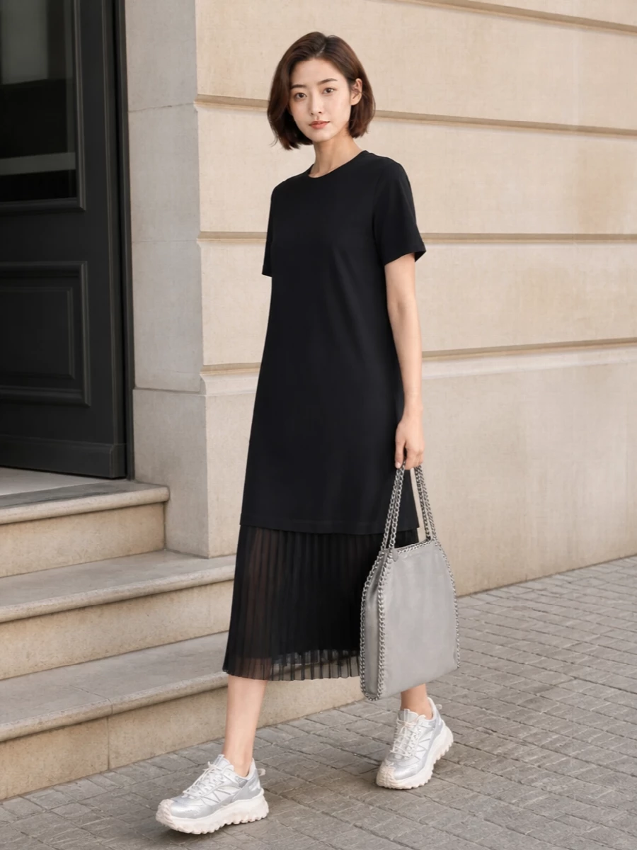 This look leans into a sporty, monochrome FW story: the black Moncler T‑shirt dress with its pleated hem gives easy movement and a clean backdrop that lets the technical silver-and-off‑white sneakers stand out. The metallic-grey chain-trim tote picks up the sneaker’s pale silver accents, sharpening the outfit into something city-ready and quietly luxe. I chose the dress route rather than top-and-bottom to keep the silhouette simple and columnar, letting the sneakers and accessories do the talking without breaking the line of the look.