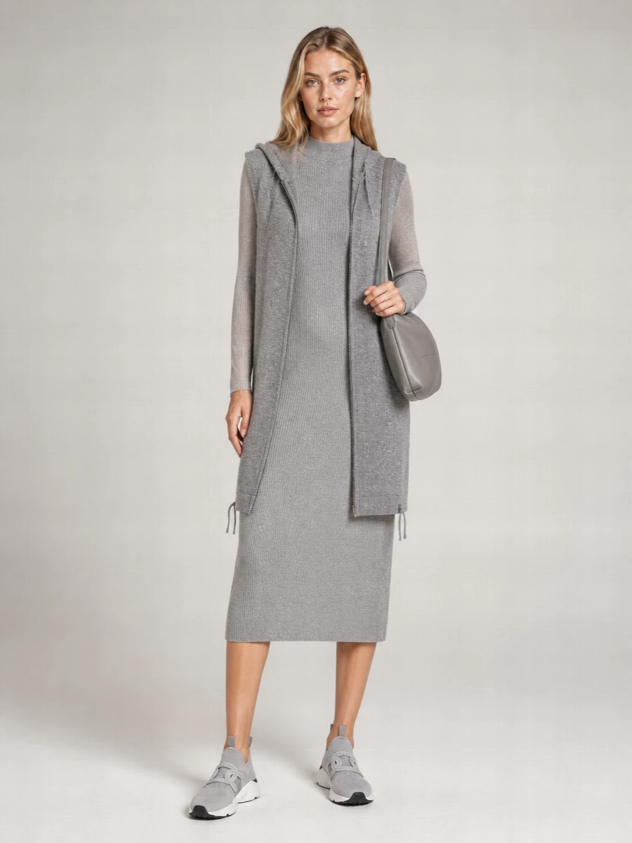 The sleeveless sequinned cardi-coat sits best over a single, elongated base, so the ribbed grey midi dress wins over separates for a clean, uninterrupted column. Tonal grey sneakers and a supple shoulder bag keep the palette hushed and the mood quietly polished, ideal for city days when you want softness, sparkle and ease in one outfit.