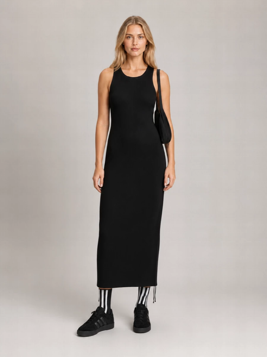 Anchoring the outfit with the Y-3 column dress lets the striped socks play directly into a sharp, monochrome, sport-meets-street story without overcomplicating things with extra separates. The suede Y-3 sneakers ground the length of the dress with a solid, urban base, while the black Alexander Wang shoulder bag adds just enough structure and tactility to keep the whole composition refined but easy. It is a clean, athletic city uniform that feels graphic, intentional and ready for all-day movement.