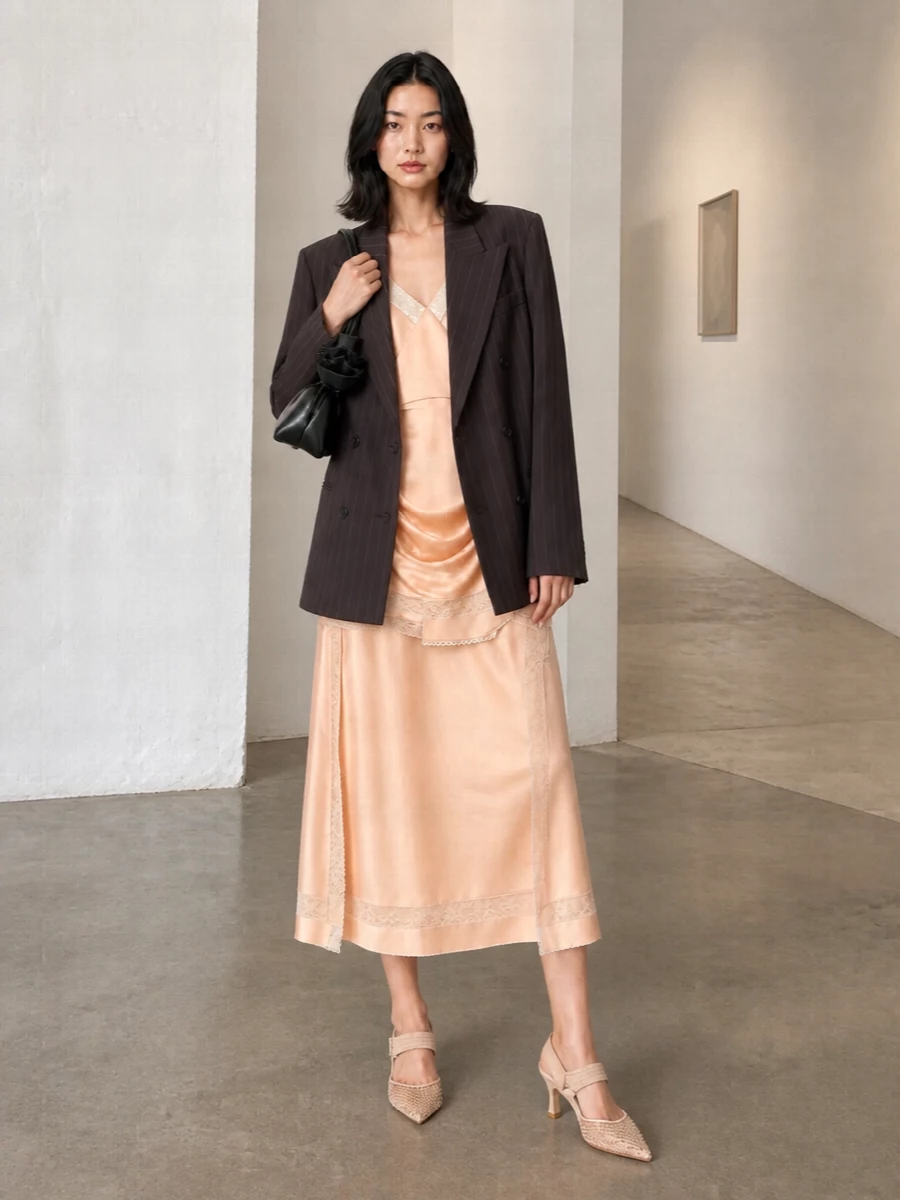 Peach satin and lace stay firmly in focus, grounded by nude embellished heels and a sleek black shoulder bag for a refined, romantic evening mood. The balance of soft blush tones with a single inky accessory keeps it sensual yet composed, perfect for cocktails or an intimate dinner in the city.