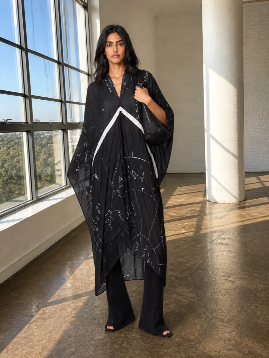 A sheer, graphic Rick kaftan and monolithic wedge boots create a dark, cinematic column that moves around the body rather than clinging. The small black hobo and astrologic scarf stay close to the body, adding utility and symbolism without disrupting the drape. It is an evening-ready composition that feels effortless yet intensely considered, ideal when you want drama with a quiet, intellectual charge.