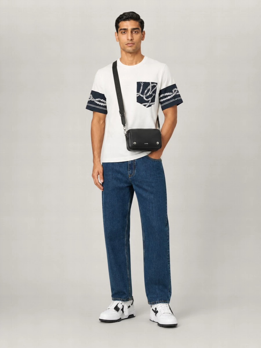 Dolce&Gabbana’s nautical tee sits against deep indigo Bally denim for a clean, quietly graphic base. Off-White court sneakers sharpen the palette with crisp black and white, keeping everything grounded in modern streetwear. A compact black Loewe crossbody finishes the mix with low-key polish and practical ease for city days.