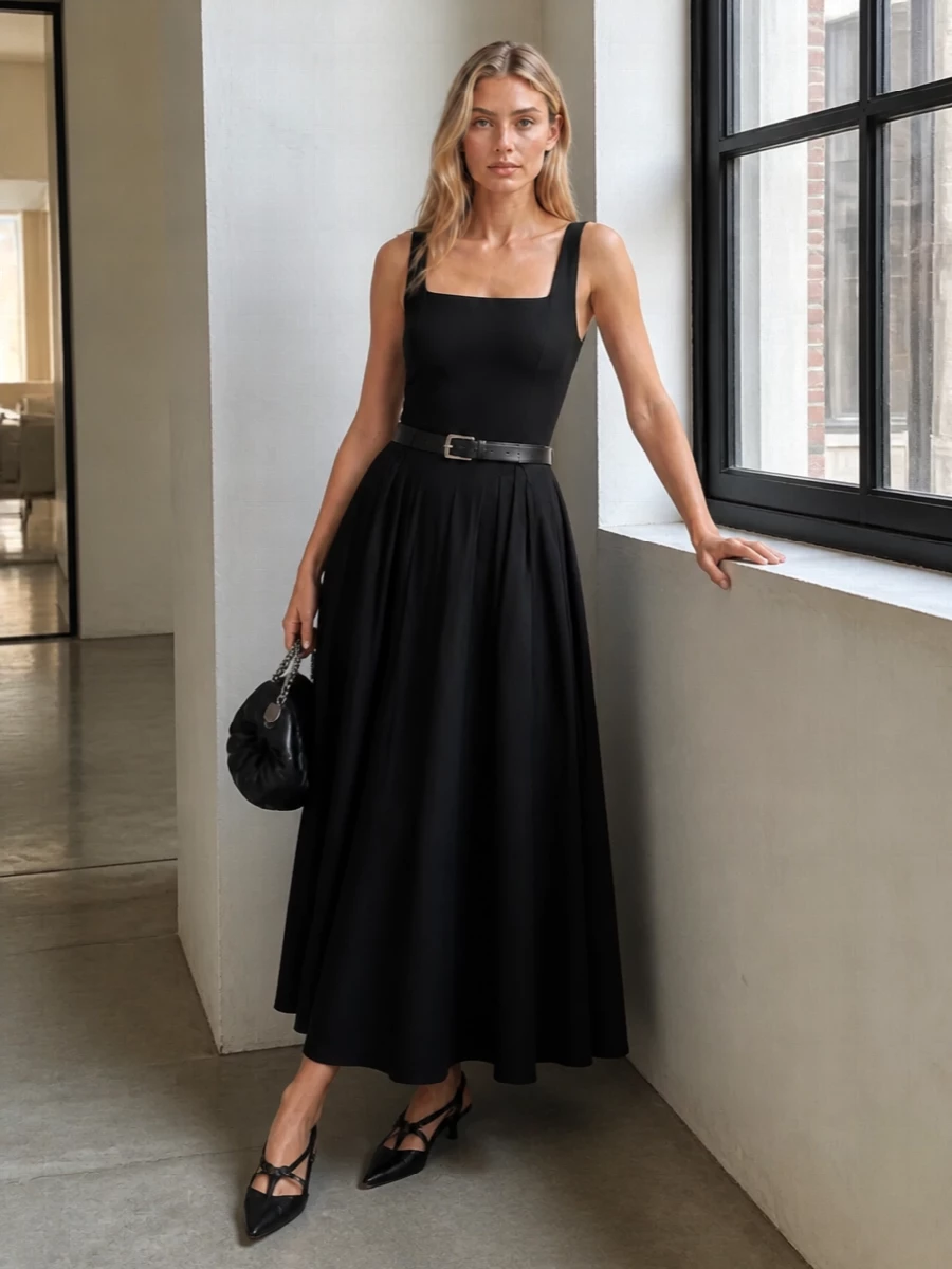This look leans into the dress’s sculpted bodice and sweeping skirt with razor-sharp black kitten-heel slingbacks and a cinched leather belt that subtly refines the waistline. A sculptural knotted clutch in black keeps everything firmly in the quiet-luxury, evening-in-the-city space, letting the clean square neckline and fluid movement of the maxi remain the focal point. The result is poised, modern and romantic without ever feeling overworked.