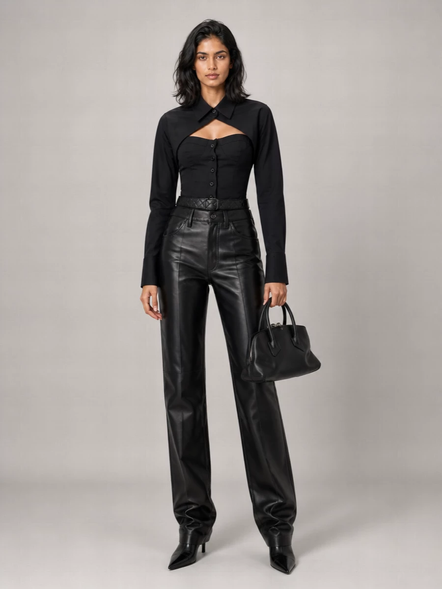 Attico’s leather trouser meets its match in the corseted black shirt, creating a precise, nocturnal column of tailoring with just enough cut-out drama. Sleek black knee-high boots extend the line, while a structured mini top-handle and a slim quilted belt keep everything sharp and controlled for city nights. The result is high-gloss power dressing that still feels subversive and Y2K-leaning from every angle.