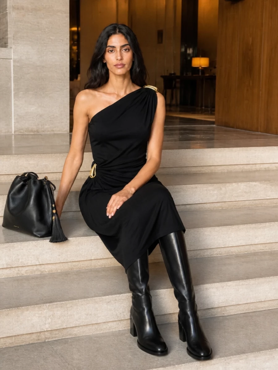A black Bottega Veneta one-shoulder midi and sleek knee-high boots let the Etro bucket bag’s tassels and gold hardware feel intentional rather than decorative. The head-to-toe black with subtle gold touches reads quietly glamorous, ideal for dinners or gallery evenings when you want presence without volume. Choosing the dress path keeps the silhouette long and fluid, perfectly in step with the bag’s soft-structured, bohemian refinement.