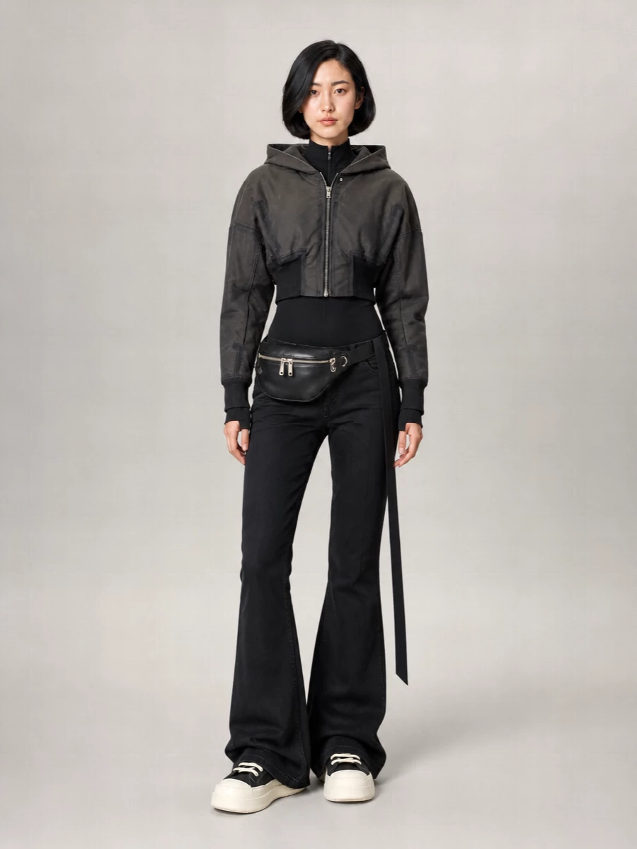 I’m building around the outerwear’s cropped, armored energy, so separates beat a dress here: the flared denim gives you that long, grounded line the bomber is craving. A second-skin hooded jersey keeps the torso dark and lean under the jacket, while the cult high-top boots and belt bag sharpen the streetwear attitude without breaking the monochrome, dystopian mood. The result is a coherent Rick-on-Rick city uniform that feels protective, directional and easy to wear all season with just a base-layer swap.