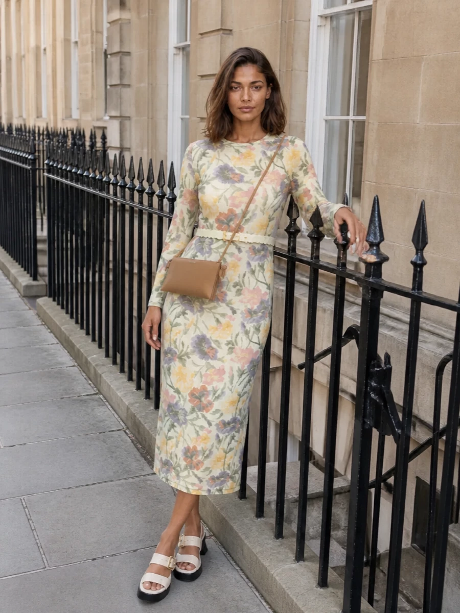 A hazy floral midi meets sculptural ivory slingbacks and a slim camel cross-body for a softly romantic, gallery-to-dinner ensemble. The pastel scalloped belt quiets and refines the print, gently framing the waist without interrupting the dress’s painterly lines. The result is feminine, polished and modern, with the texture kept light and the palette whisper-soft.