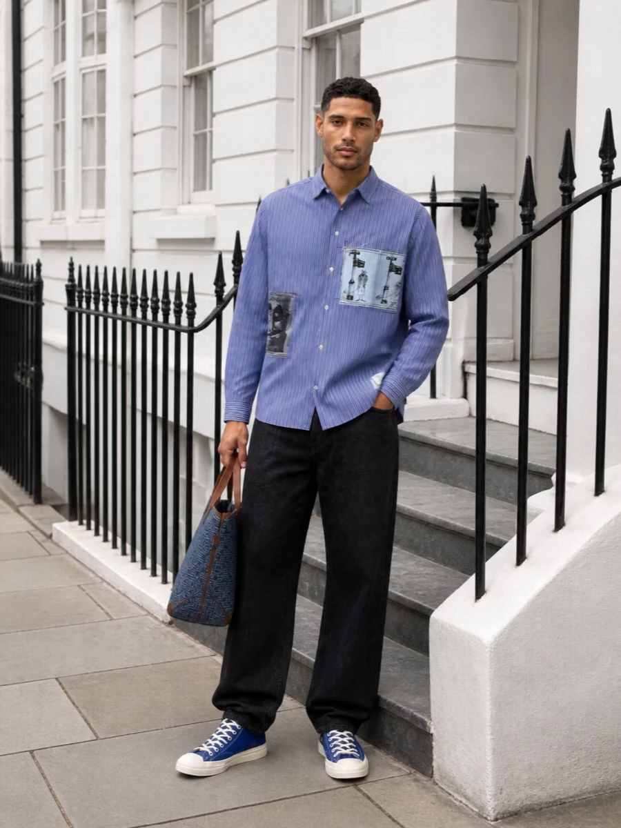 Graphic Comme des Garçons shirting meets a clean high-rise wide-leg in washed black, giving a considered, art-school spin on smart-casual. Cobalt high-tops and a structured blue tote pick up the shirt’s color story while the black accessories quietly anchor everything. The result feels clever, relaxed and sharp enough for gallery days and late café evenings alike.
